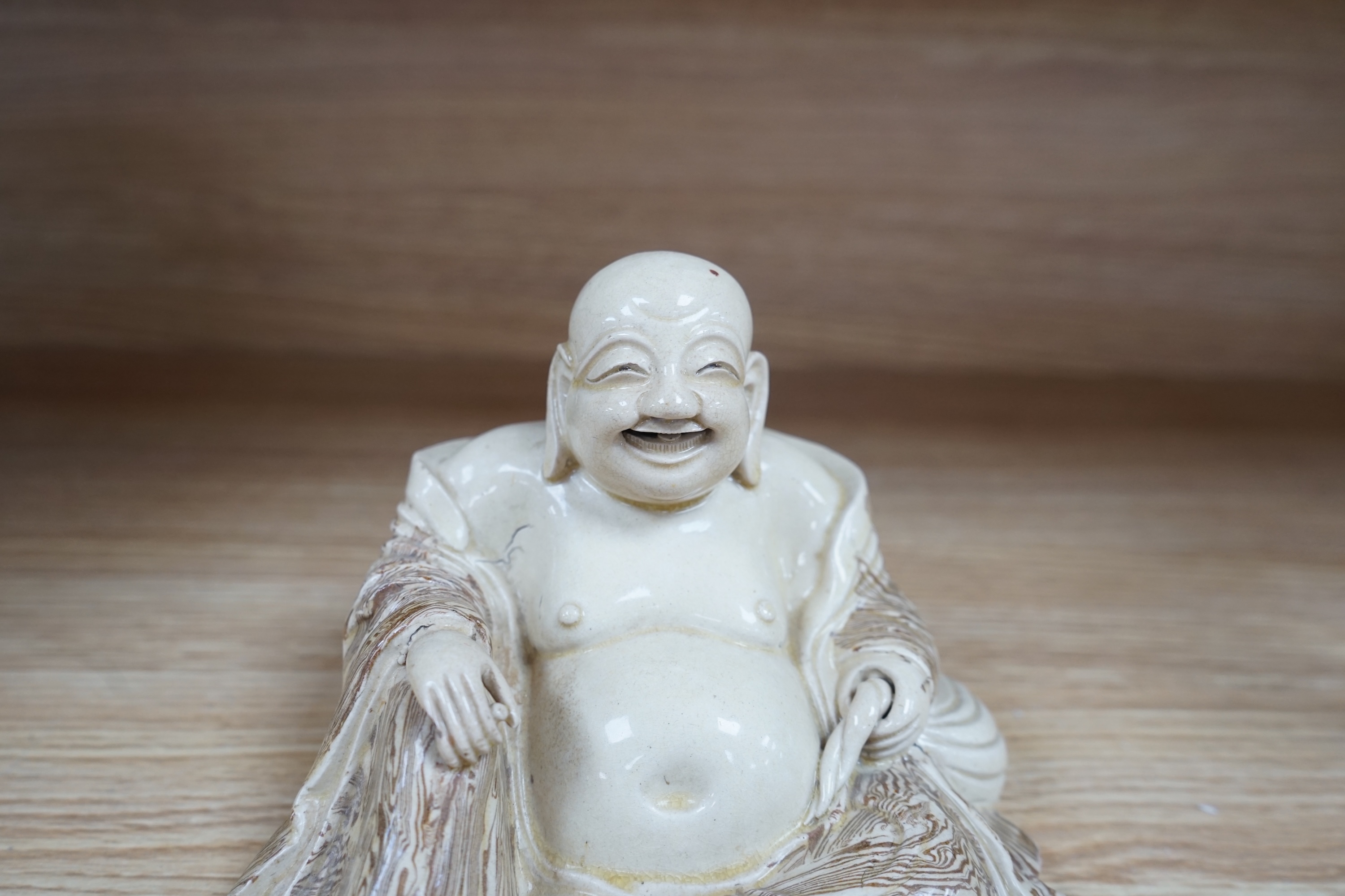 A Chinese marbled pottery figure of Budai, early 20th century, 13cm high. Condition - fair to good.